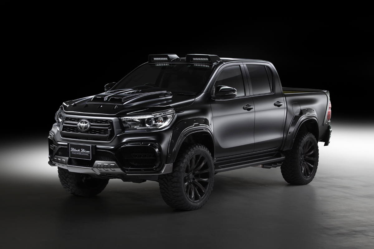 WALD Toyota Hilux GUN125 Black Bison front three-quarter studio view showing front bumper spoiler and wide arch package