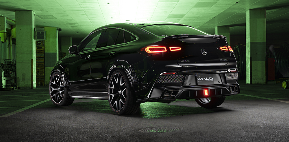 WALD Black Bison Mercedes GLE Coupe C167 rear three-quarter night view with illuminated LED brake lamp and quad exhaust tips