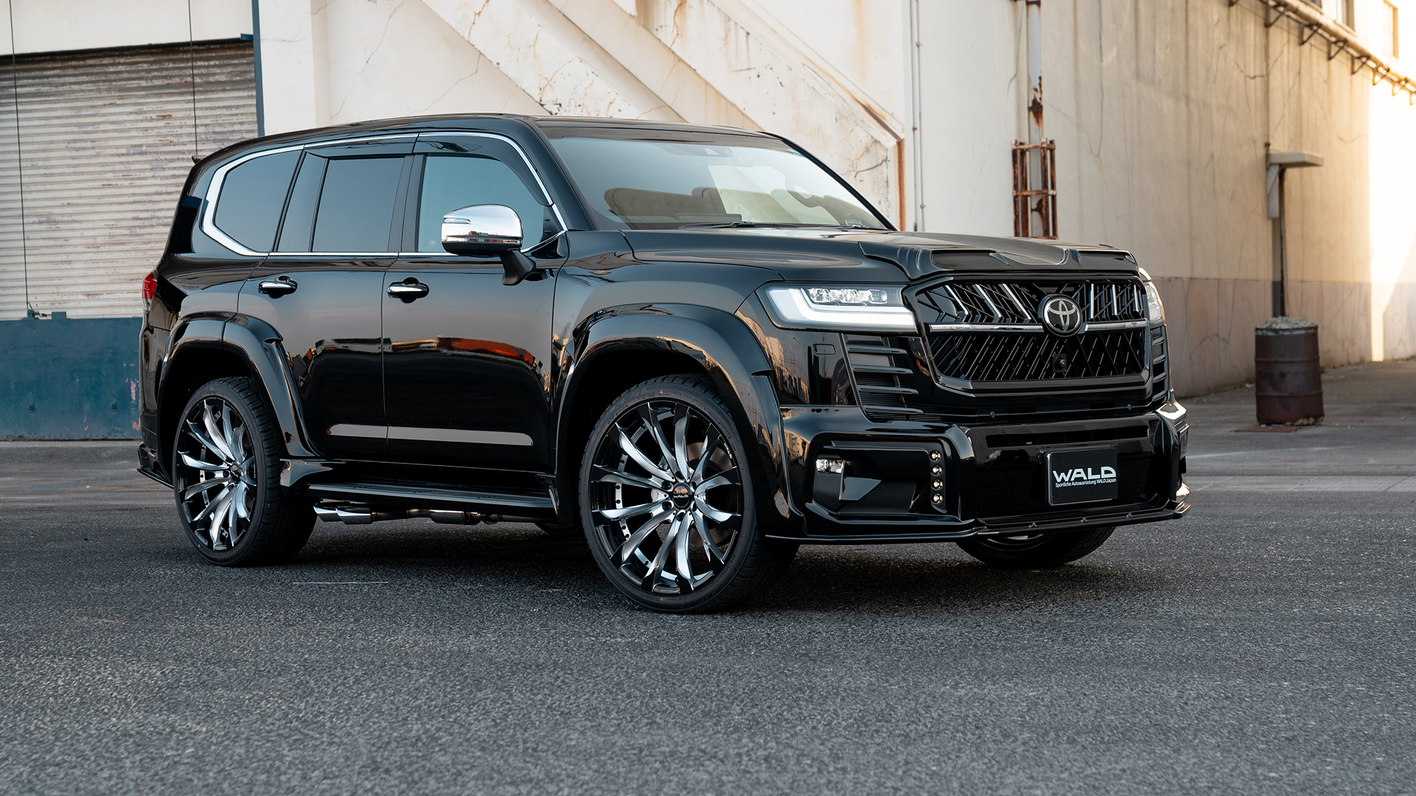 WALD Black Bison Toyota Land Cruiser 300 ZX in gloss black, front three-quarter view on 24-inch WALD wheels