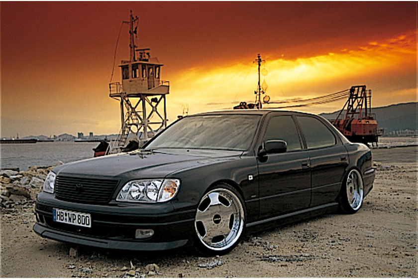 WALD Executive Line V3 Toyota Celsior UCF20/21 — black Celsior front three-quarter view at sunset with WALD front spoiler and deep-dish wheels