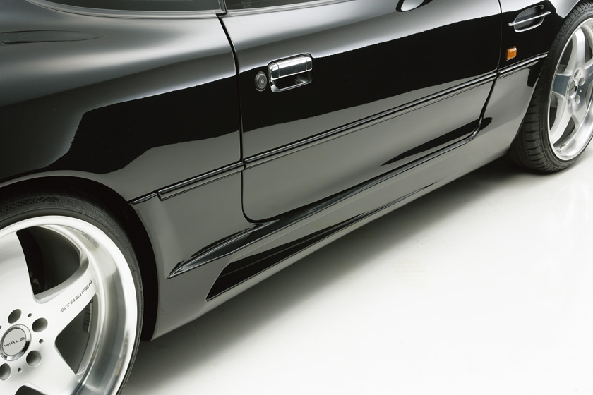 WALD Aston Martin DB7 side skirt detail — WALD Sports Line side skirt along the sill of a black DB7