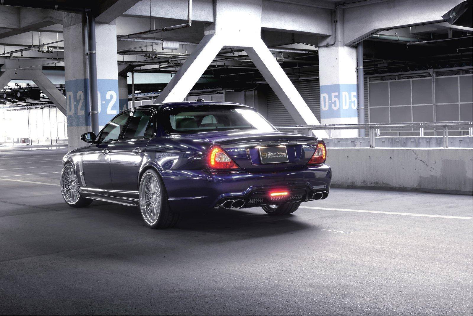 WALD Black Bison Jaguar XJ X358 rear three-quarter view in a multi-storey car park with quad exhaust tips and LED rear lamp