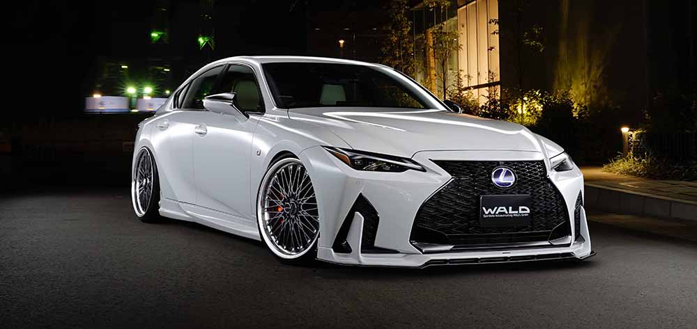 WALD Sports Line Lexus IS — white Lexus IS F SPORT front three-quarter at night with WALD front spoiler and side skirts