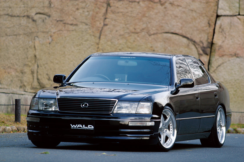 WALD Executive Line Toyota Celsior UCF20/21 M/C before — black Celsior front three-quarter view before a stone wall with WALD front spoiler and five-spoke wheels