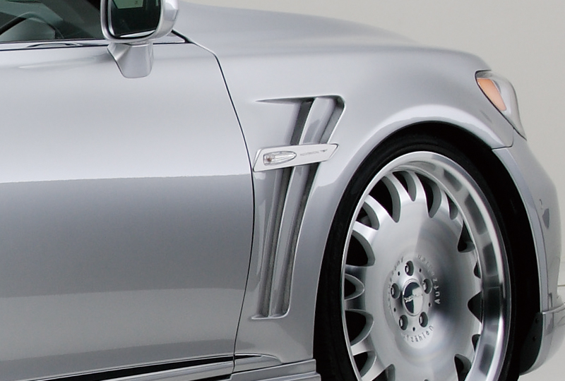 WALD Lexus LS600h sport fender duct with side emblem plate beside a polished multi-spoke WALD wheel