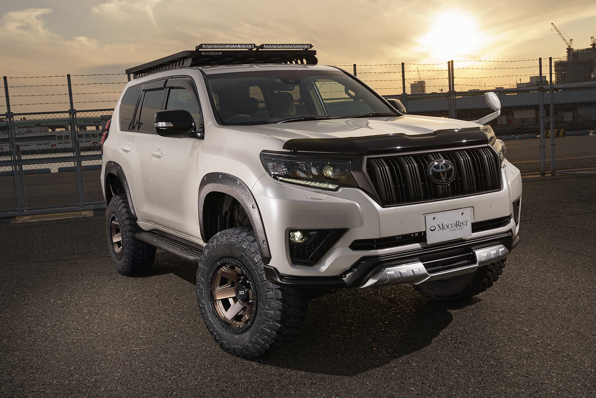 White Toyota Land Cruiser Prado with roof rack fitted with WALD Desert Line DS001 wheels at sunset