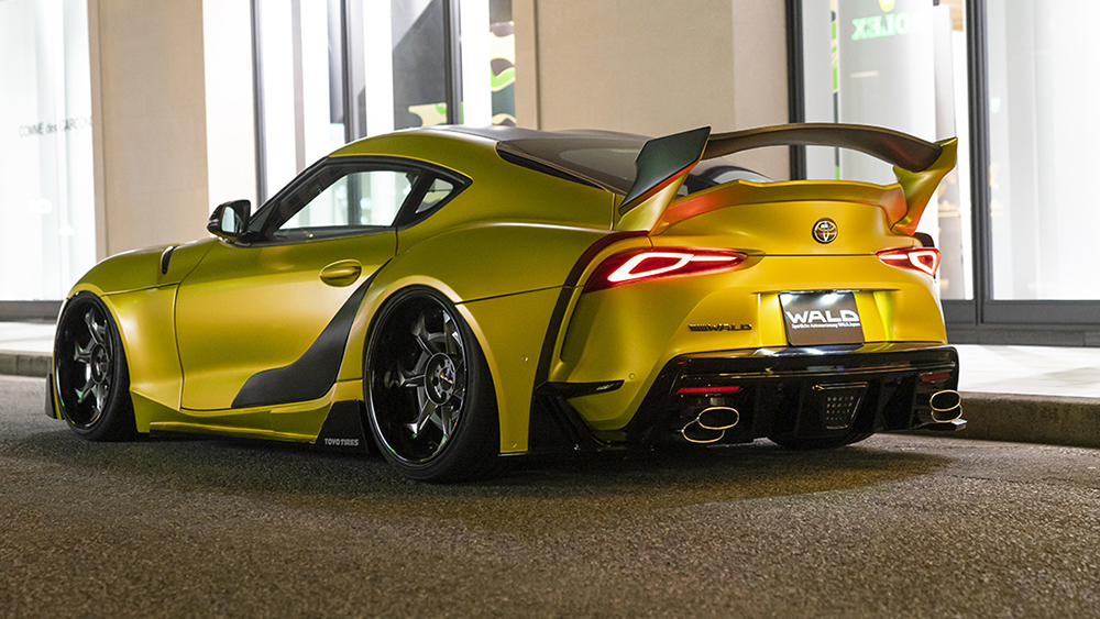 Yellow WALD wide body Toyota Supra rear three-quarter view with rear diffuser, quad exhaust tips and 3D rear wing