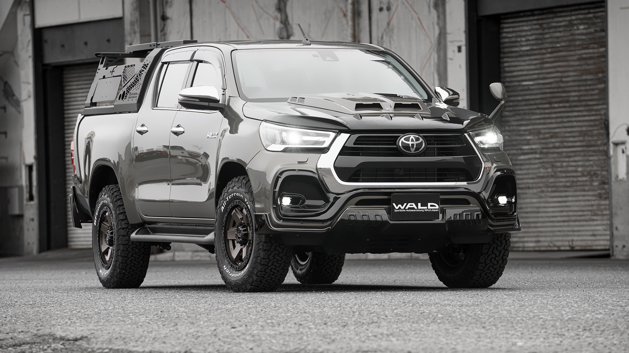 WALD Sports Line Black Bison Toyota Hilux GUN125 facelift in dark grey with full-bumper front styling and bronze WALD wheels