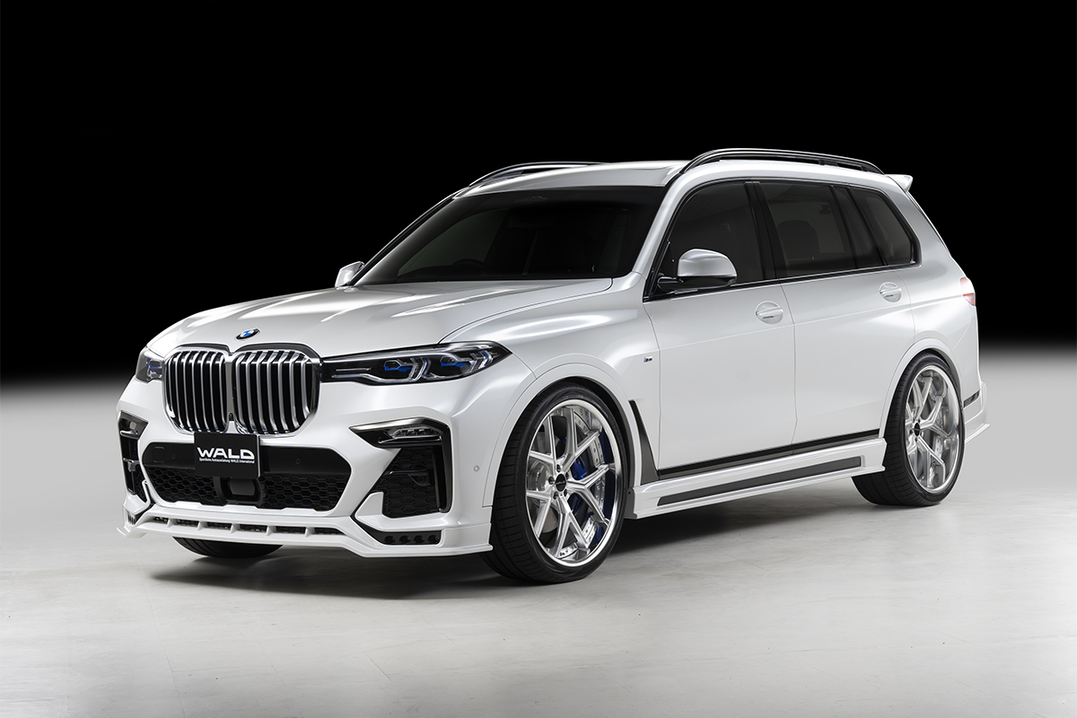 WALD Sports Line BMW X7 G07 Black Bison body kit — white BMW X7 front three-quarter studio view with WALD front spoiler, side skirts and forged wheels