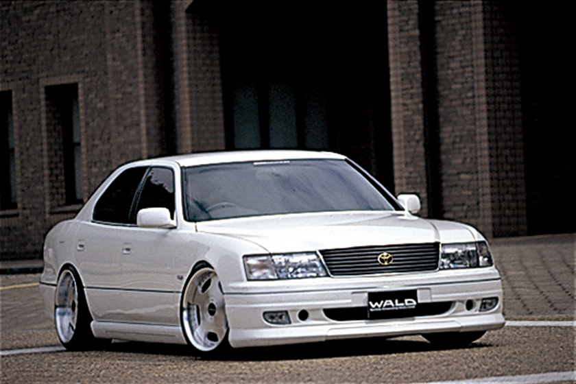 WALD Executive Line V3 Toyota Celsior UCF20/21 M/C before — white Celsior front three-quarter view in front of a brick building with WALD front spoiler and grille detail