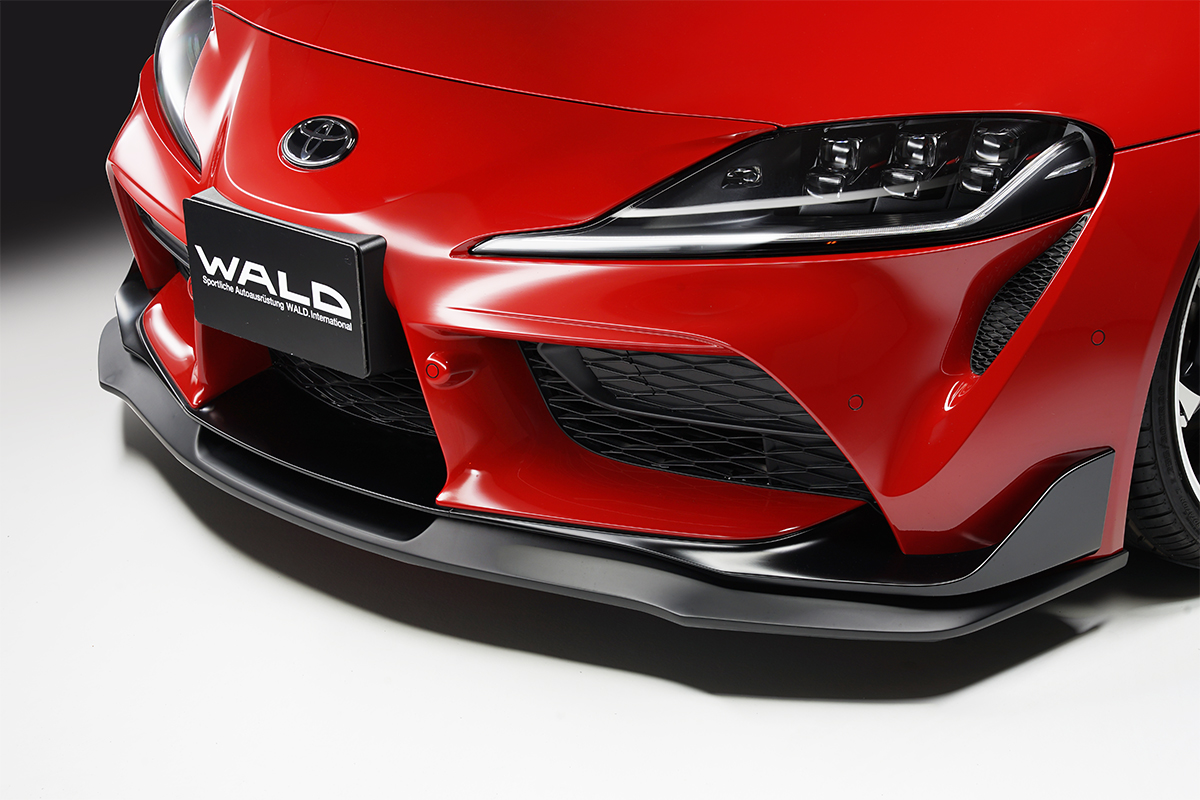 WALD front lip spoiler detail on the red Toyota Supra DB## in gloss black