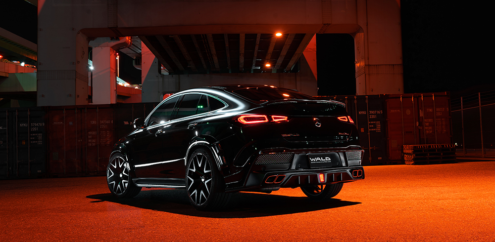 WALD Black Bison Mercedes GLE Coupe C167 rear three-quarter night view under overpass with quad trapezoid exhaust tips