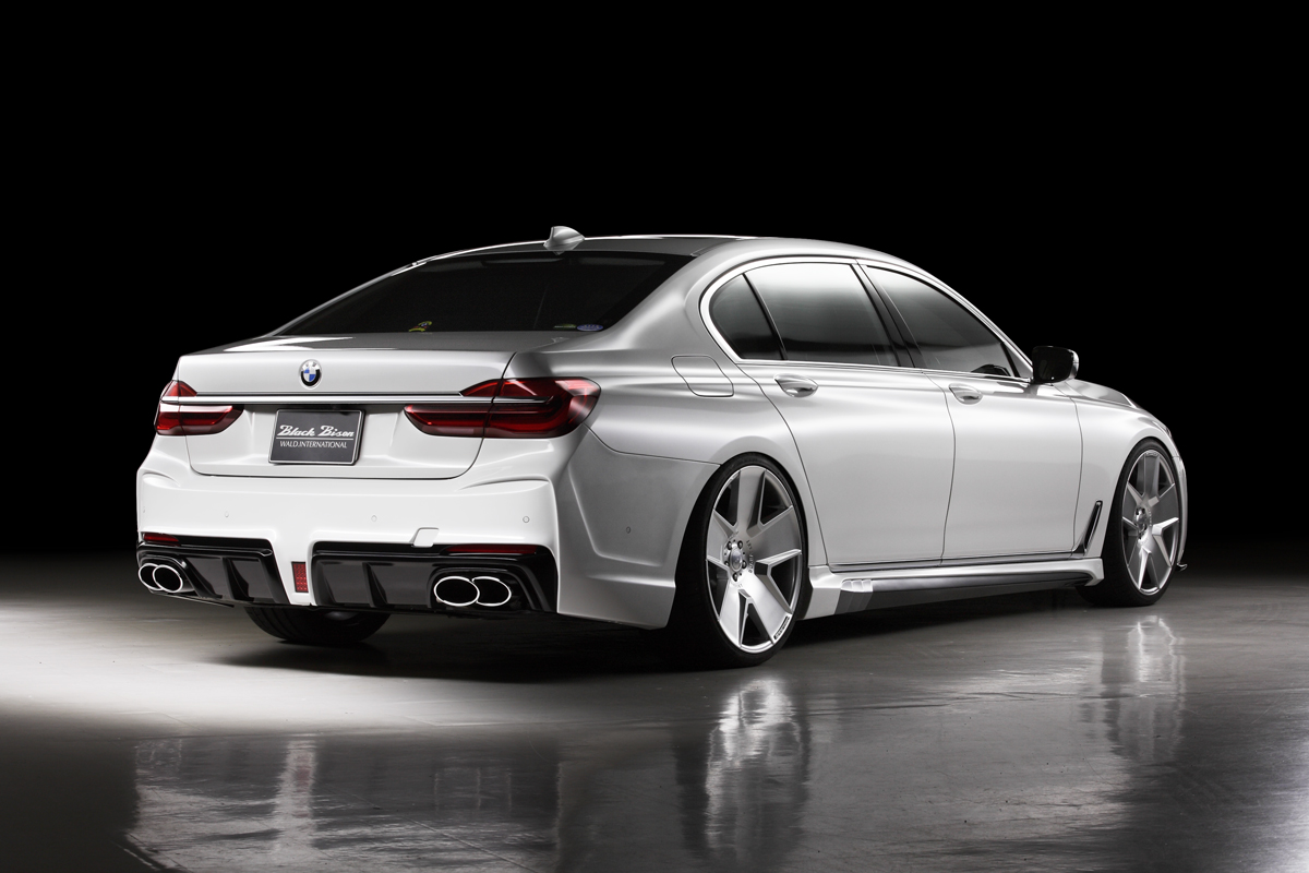 WALD BMW 7 Series G12 Black Bison rear three-quarter studio view showing WALD rear bumper spoiler and twin quad exhaust tips