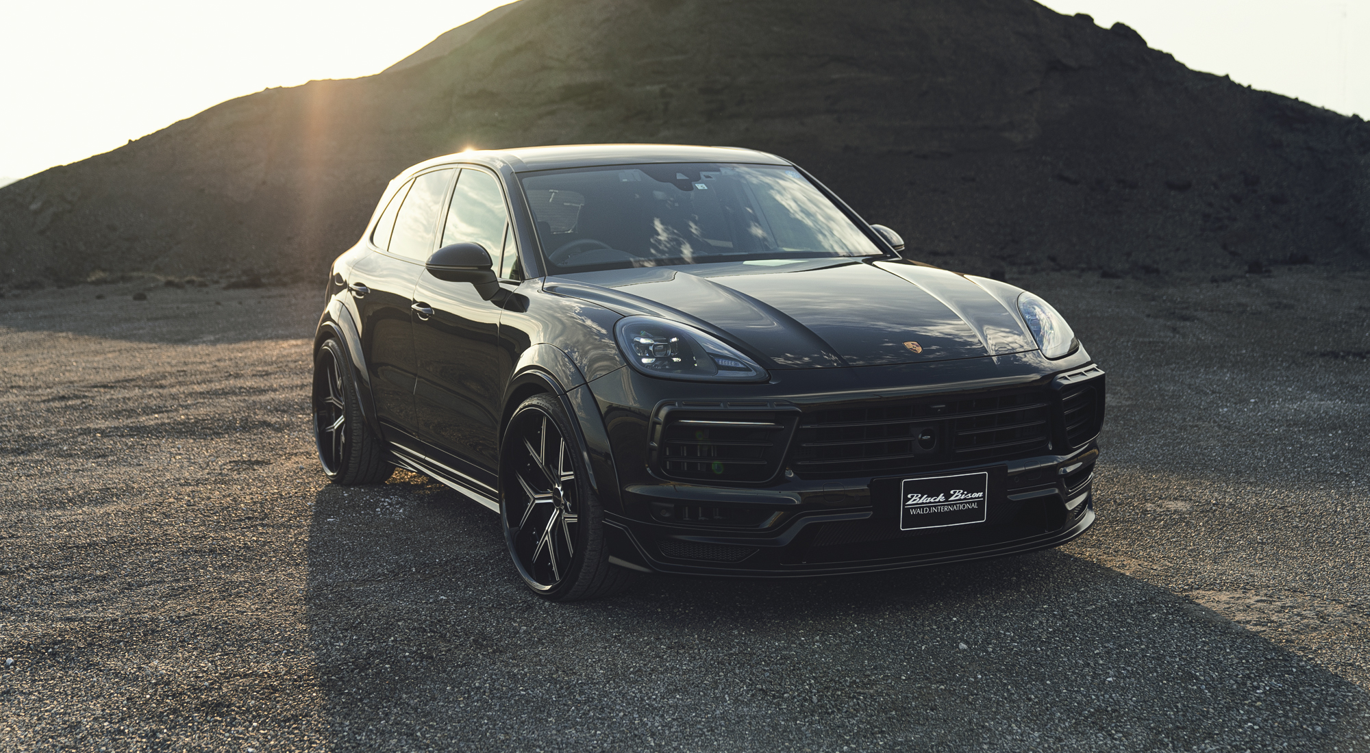WALD Porsche Cayenne 9YA front three-quarter view outdoors with WALD wide arch package and front spoiler