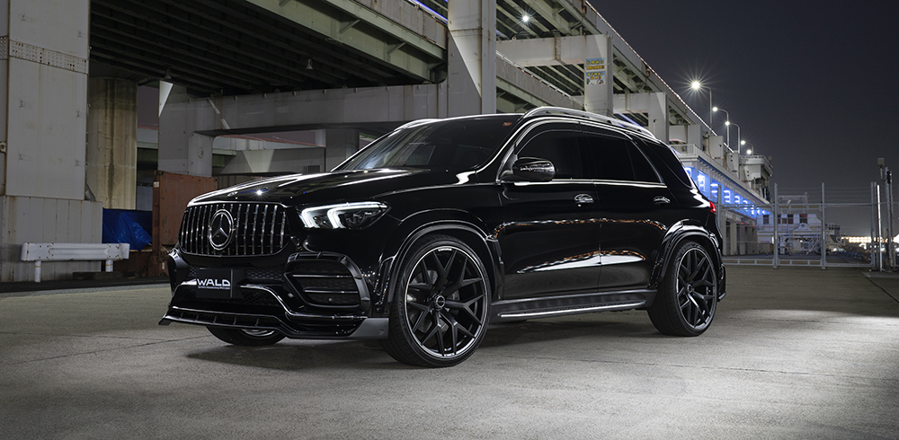 WALD Black Bison Mercedes GLE W167 front three-quarter night view under city overpass with wide arches and Panamericana grille