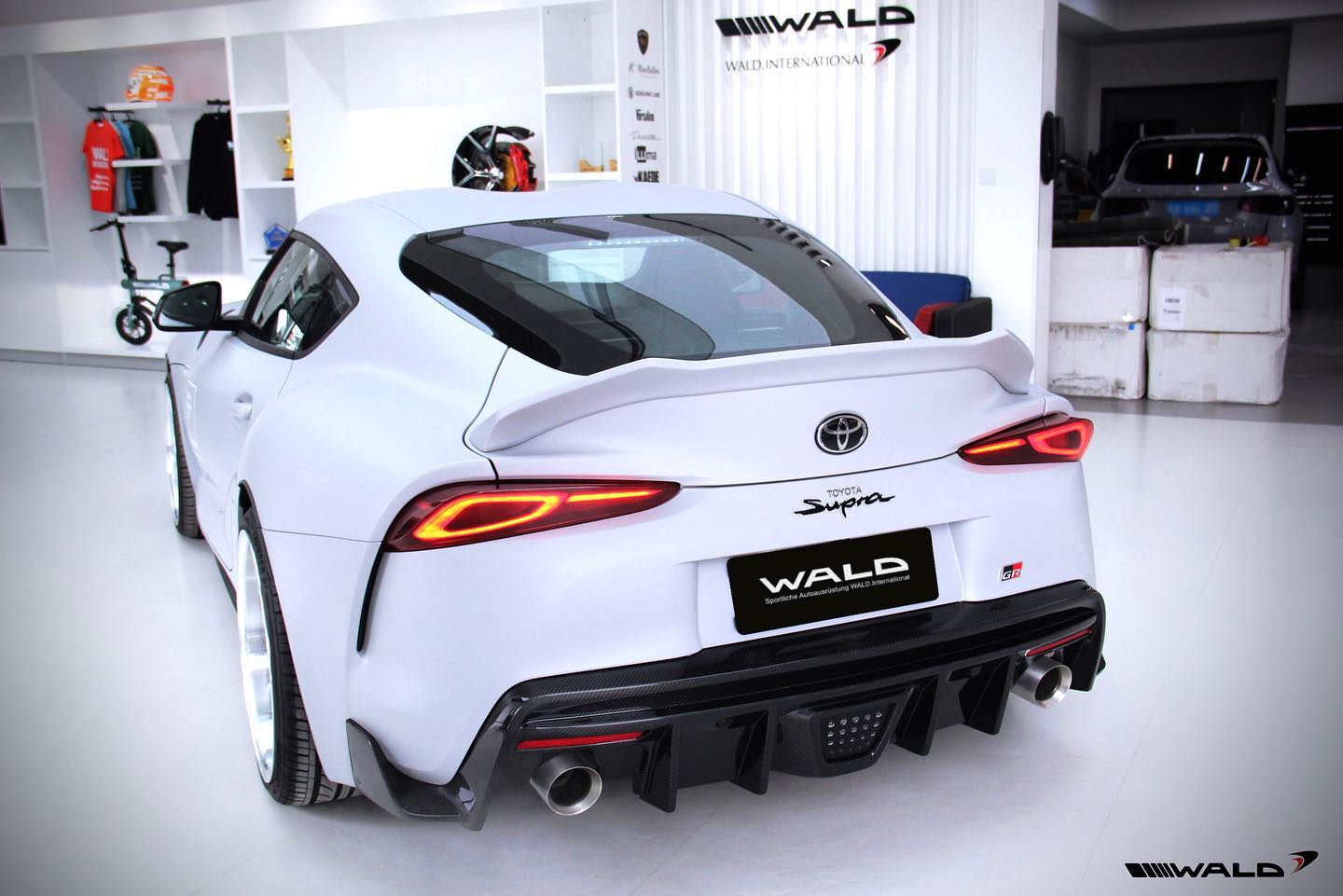 WALD Sports Line Toyota Supra DB## non-wide body — white Supra rear three-quarter view with WALD rear wing, carbon rear diffuser and twin exhaust outlets