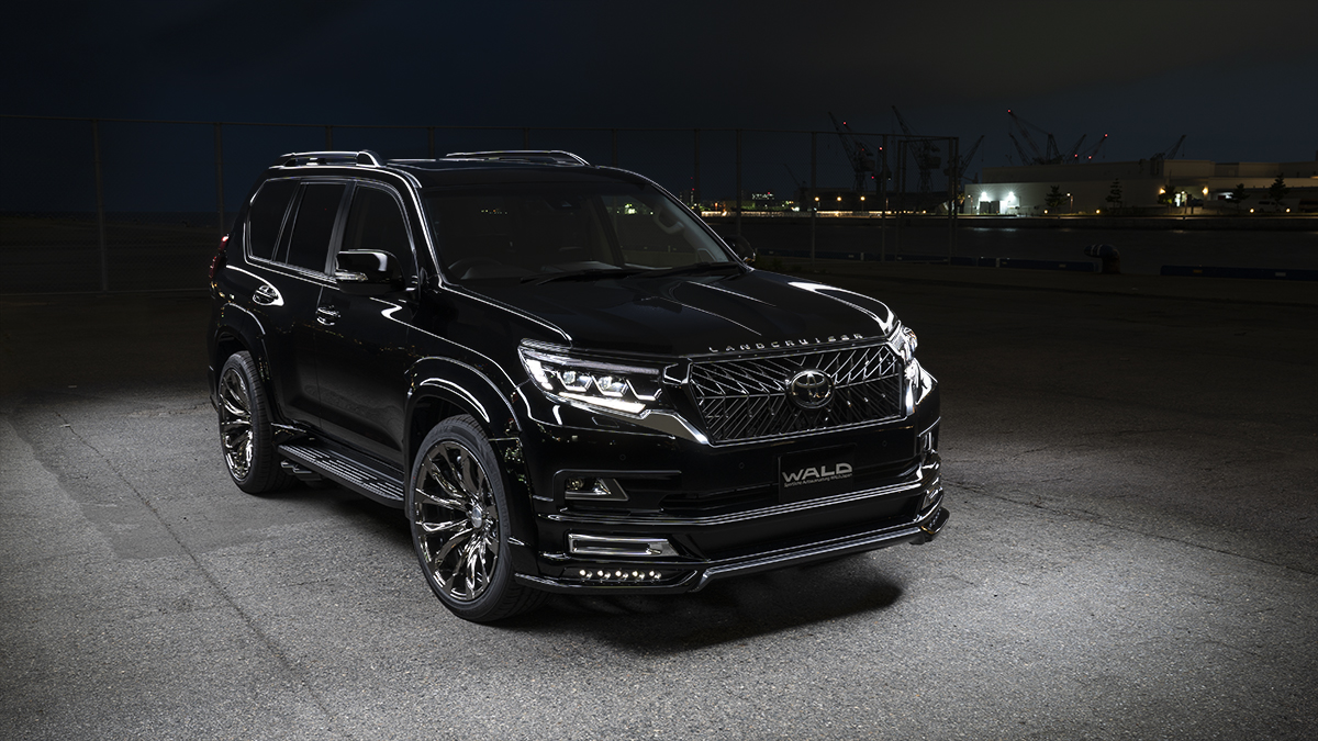 WALD Black Bison Edition Toyota Land Cruiser Prado 150 at night on the dockside with wide arch package and chrome WALD wheels