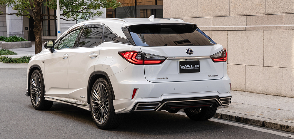 White WALD Lexus RX450h F SPORT rear three-quarter view with roof wing and rear skirt