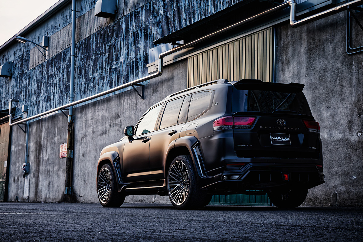 Rear three-quarter view of a WALD Black Bison Land Cruiser 300 on BM001 24 inch Black Polish wheels