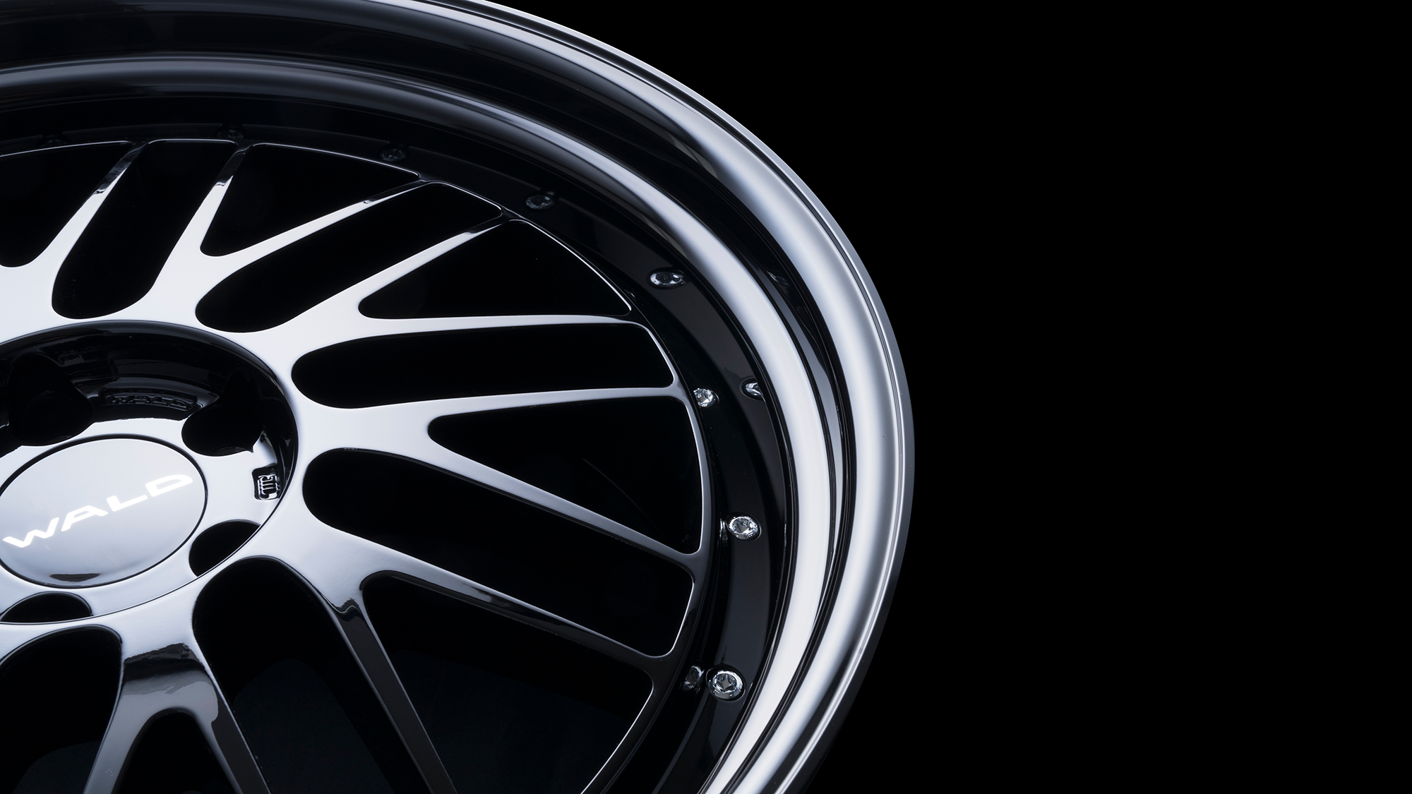 Macro detail of the WALD TOSCA II T22-C black polished rim, spokes and stainless rim bolts